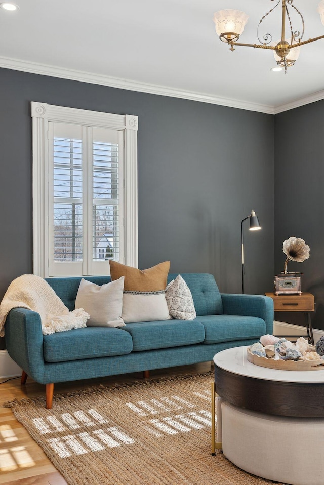 living room with crown molding, a chandelier, and hardwood / wood-style floors