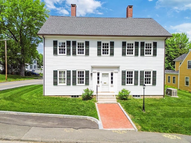 21 Academy St, Hallowell, ME 04347 - colonial inspired home featuring a front lawn, a chimney, and central AC unit