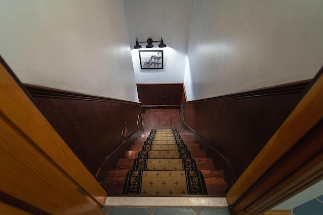 stairs featuring wood walls