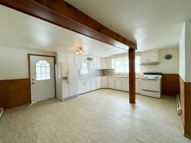 kitchen with wood walls, white cabinets, white appliances, beam ceiling, and a baseboard heating unit