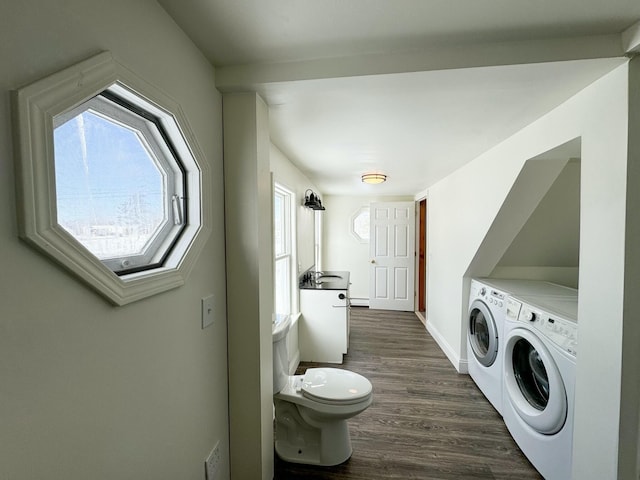 clothes washing area with dark wood-type flooring and washing machine and clothes dryer