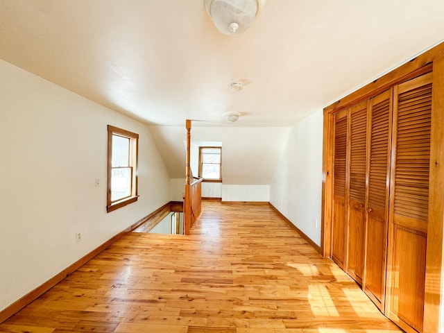 bonus room featuring vaulted ceiling and light wood-type flooring