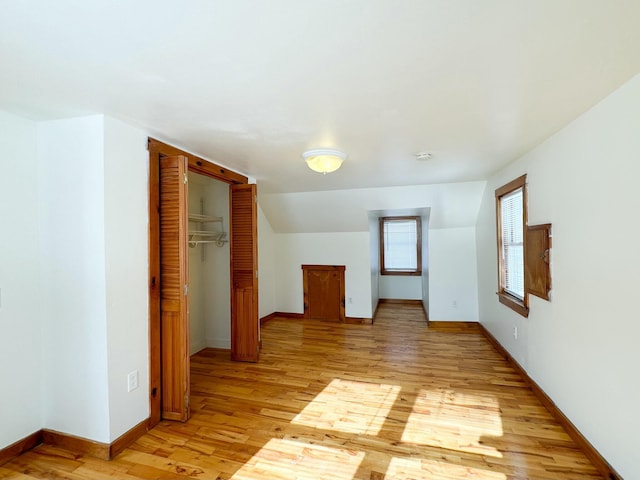 additional living space featuring lofted ceiling and light wood-type flooring