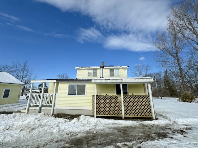 snow covered property featuring covered porch