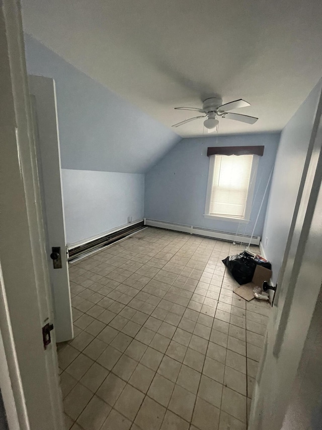 bonus room with lofted ceiling, a baseboard heating unit, light tile patterned floors, and ceiling fan