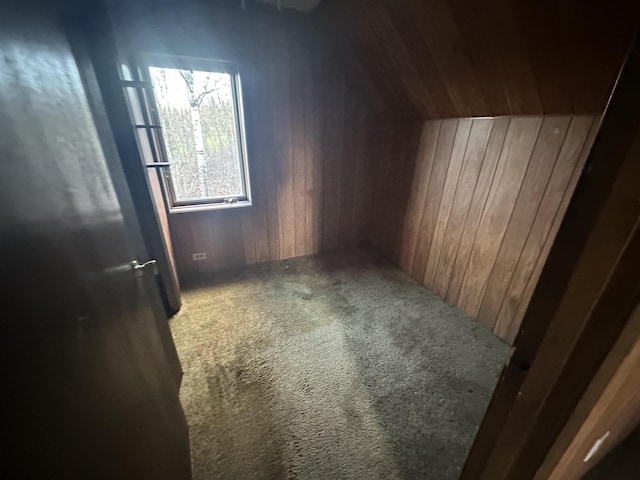 bonus room with carpet flooring and wooden walls