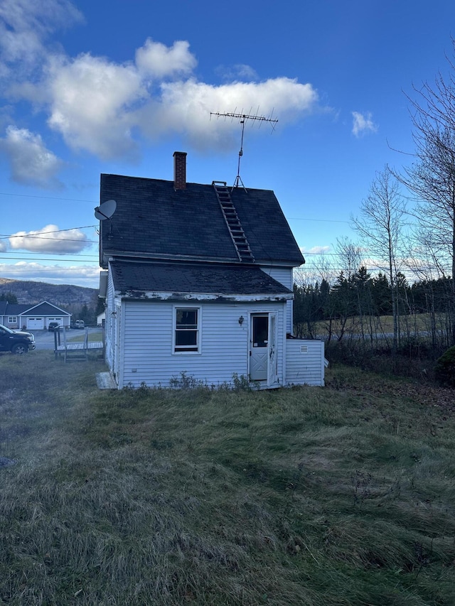 back of house featuring a lawn