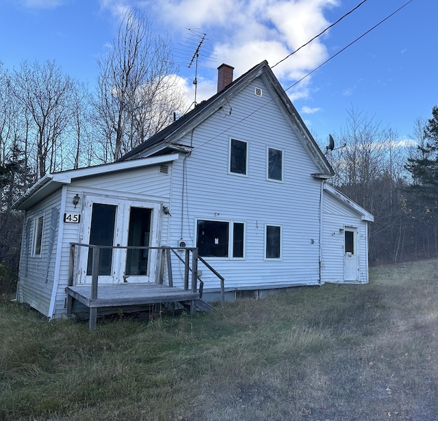 rear view of property with a lawn and a deck