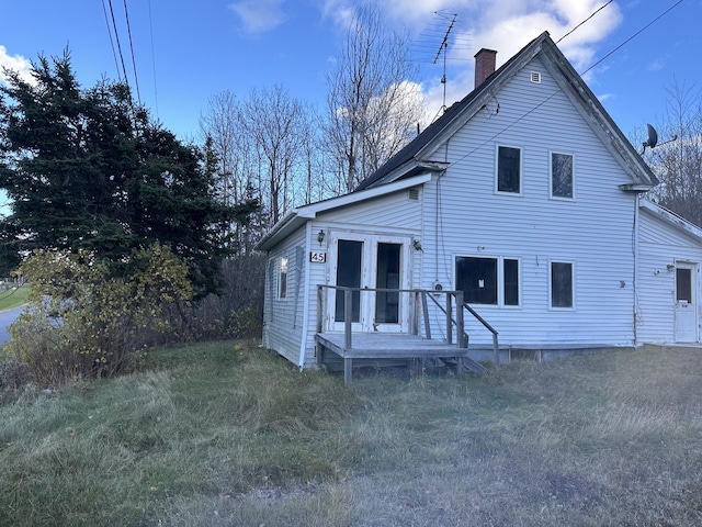 back of house with french doors and a yard