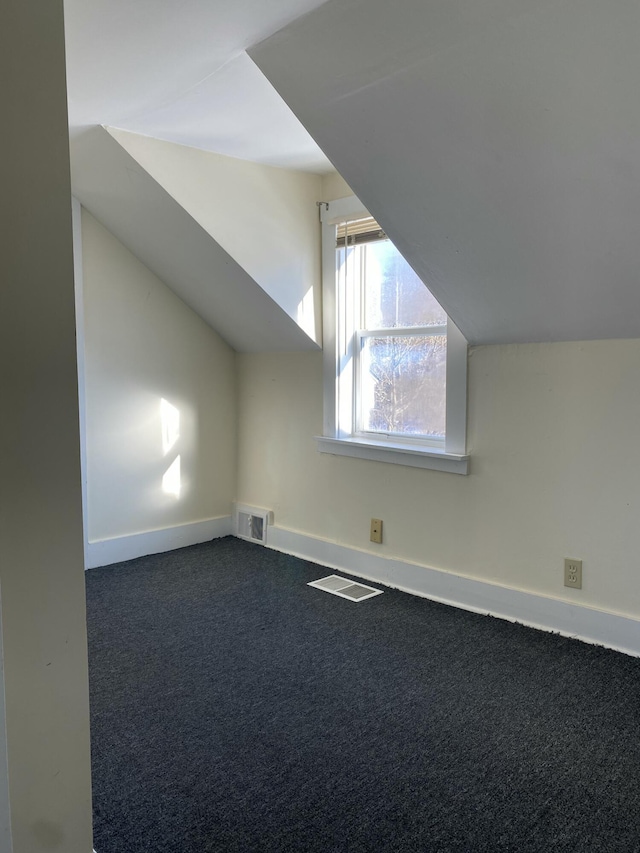 bonus room featuring lofted ceiling and dark carpet