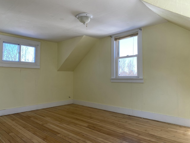 bonus room featuring a healthy amount of sunlight, vaulted ceiling, and light hardwood / wood-style flooring