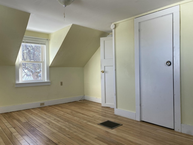 additional living space featuring lofted ceiling and light wood-type flooring