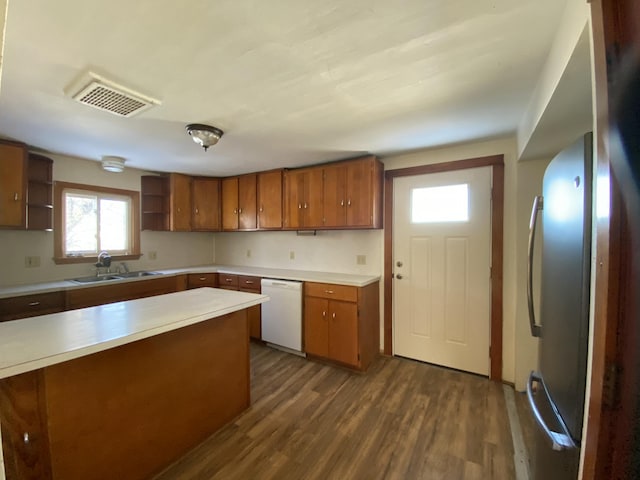 kitchen featuring dark hardwood / wood-style flooring, sink, stainless steel refrigerator, and dishwasher