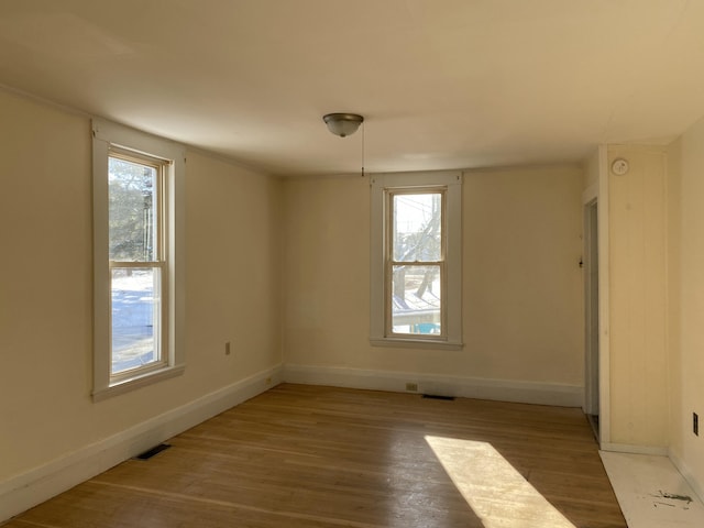 unfurnished room with plenty of natural light and light hardwood / wood-style floors