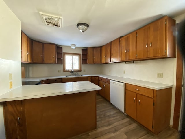 kitchen featuring white dishwasher, sink, dark hardwood / wood-style floors, and kitchen peninsula