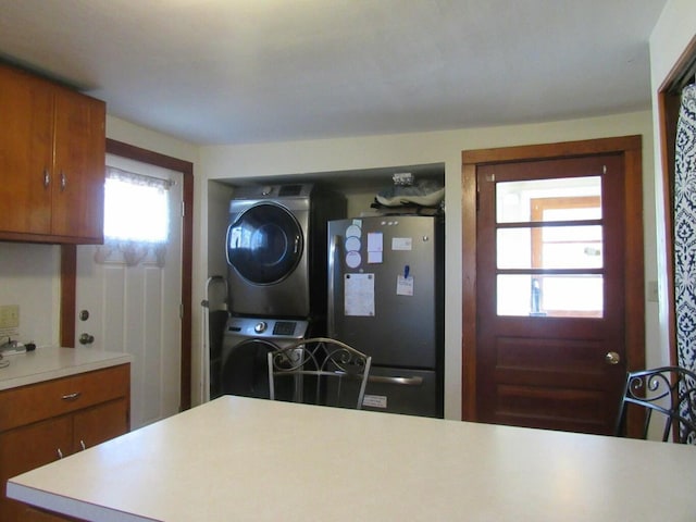 kitchen with stacked washer and clothes dryer and stainless steel fridge