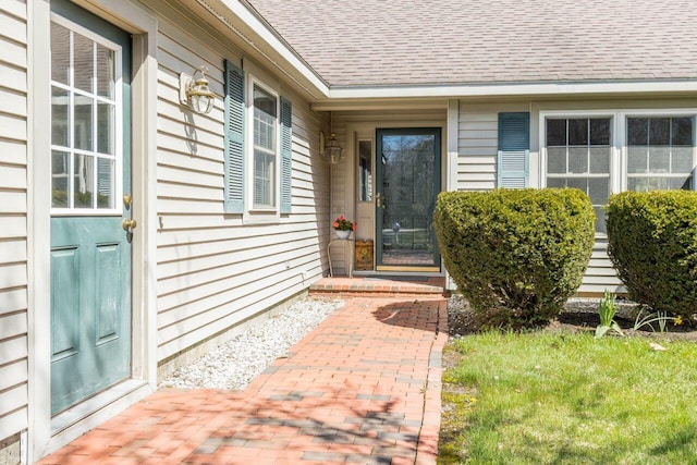 entrance to property featuring a shingled roof