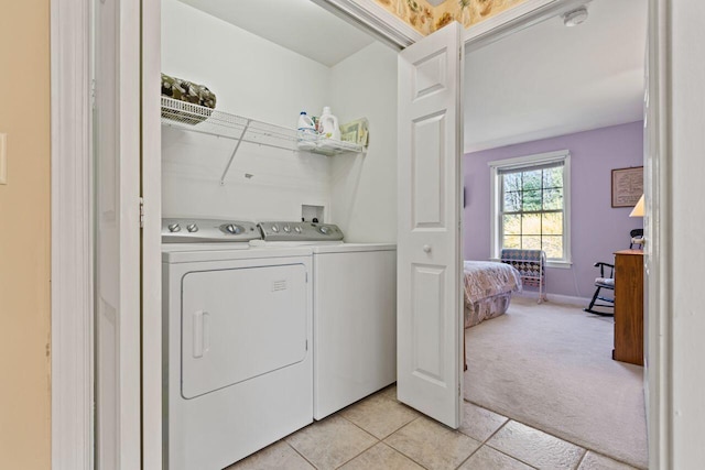 washroom featuring washer and dryer, laundry area, light carpet, and light tile patterned floors