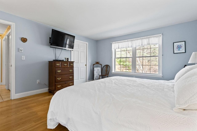 bedroom with baseboards and wood finished floors