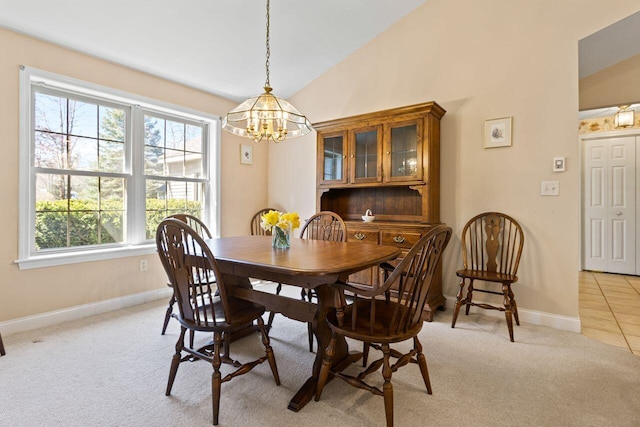 dining space with baseboards, light carpet, vaulted ceiling, and a chandelier