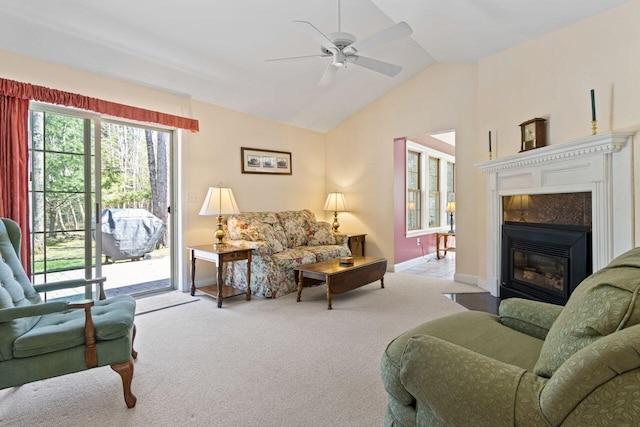 carpeted living room with baseboards, ceiling fan, a fireplace, and vaulted ceiling