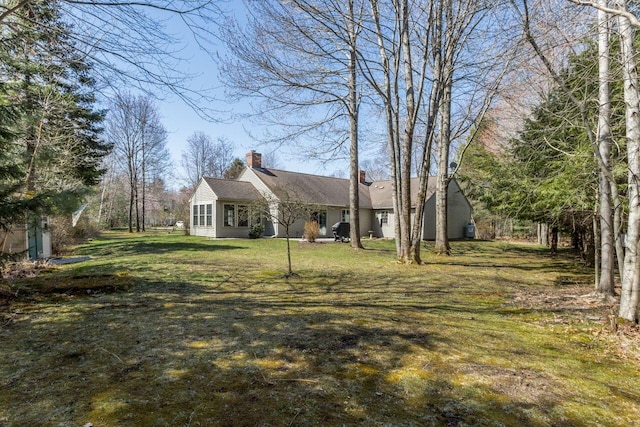 exterior space featuring a lawn and a chimney