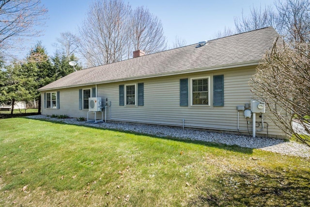 back of house with ac unit, roof with shingles, a yard, and a chimney