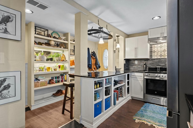 kitchen with stainless steel appliances, visible vents, white cabinetry, open shelves, and dark countertops