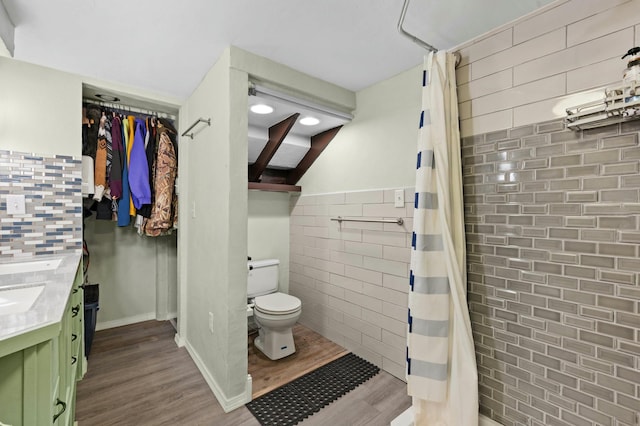 full bath featuring curtained shower, tile walls, toilet, and wood finished floors