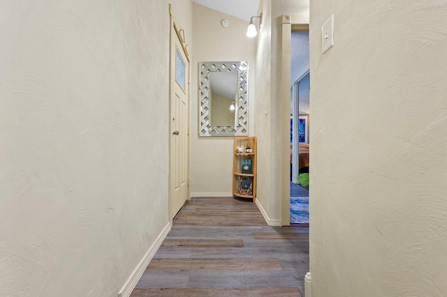 hall with baseboards and wood finished floors