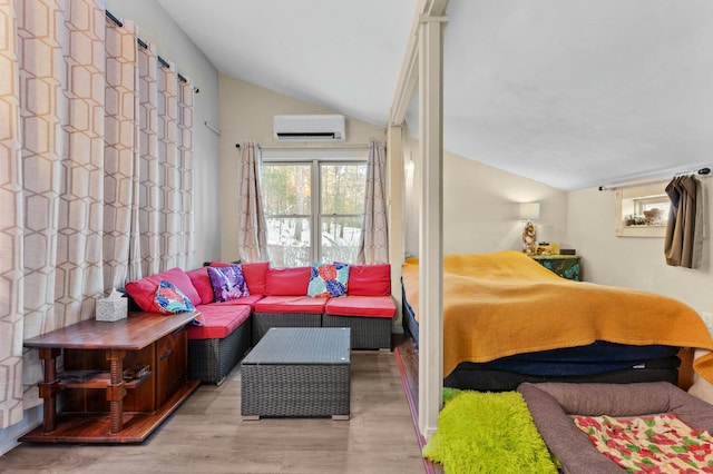 bedroom featuring vaulted ceiling, an AC wall unit, and wood finished floors