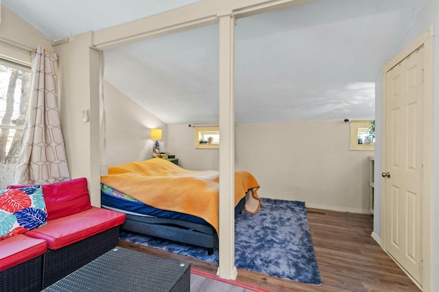 bedroom featuring lofted ceiling, wood finished floors, and baseboards