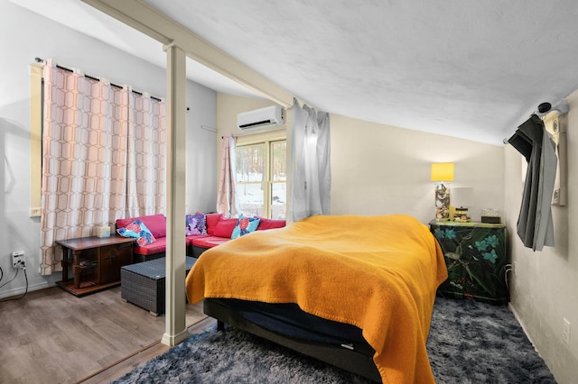 bedroom featuring lofted ceiling, an AC wall unit, and wood finished floors