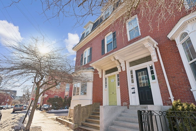 view of exterior entry featuring brick siding