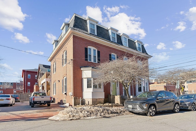 view of front of house with brick siding and mansard roof