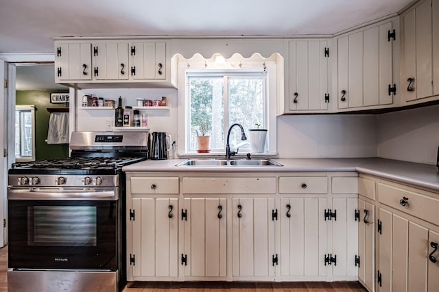 kitchen with white cabinetry, sink, and stainless steel range with gas stovetop