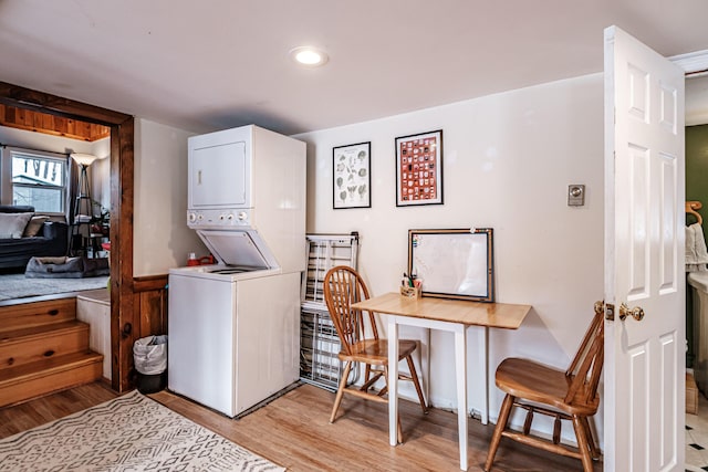 laundry room featuring stacked washer and dryer and light wood-type flooring