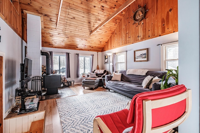 living room featuring wood-type flooring, lofted ceiling, a wood stove, and wood ceiling