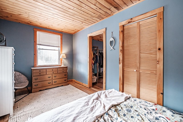 bedroom featuring wood ceiling, a closet, and light wood-type flooring