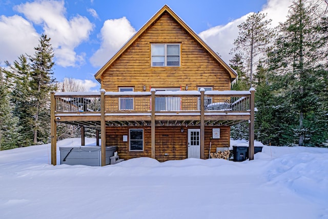 snow covered house featuring a wooden deck