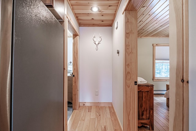 corridor featuring a baseboard radiator, light hardwood / wood-style flooring, and wooden ceiling