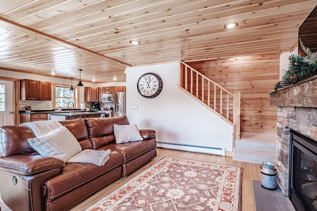 living room with sink, wooden ceiling, a baseboard radiator, a fireplace, and light hardwood / wood-style floors