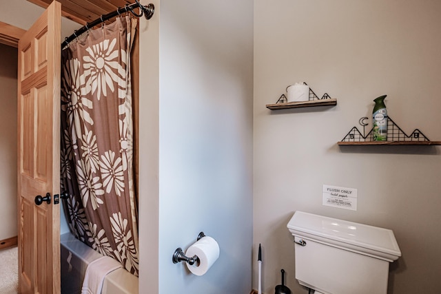 bathroom featuring shower / bathtub combination with curtain and toilet