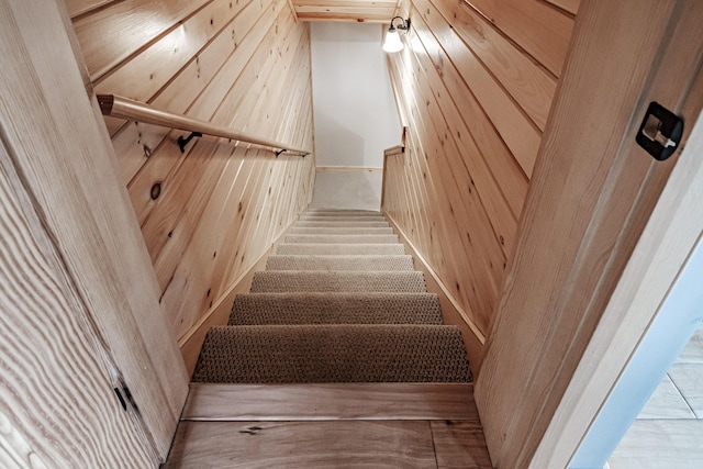 stairs featuring wood walls