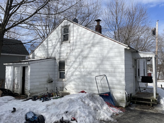 snow covered property featuring a chimney