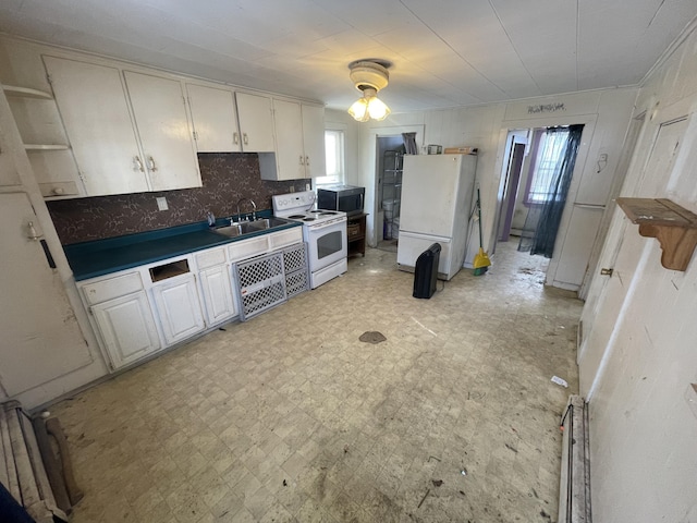 kitchen featuring white appliances, dark countertops, backsplash, light floors, and a sink