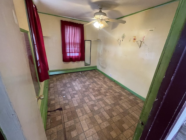 spare room with a ceiling fan, a baseboard radiator, brick patterned floor, and baseboards