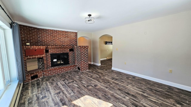 unfurnished living room featuring baseboards, arched walkways, dark wood-type flooring, a fireplace, and a baseboard heating unit