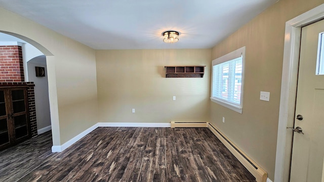 empty room with baseboards, arched walkways, dark wood-style floors, a baseboard radiator, and baseboard heating