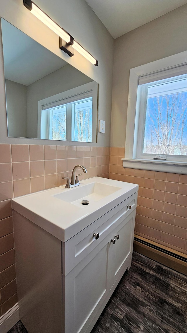 bathroom featuring plenty of natural light, wood finished floors, vanity, and tile walls